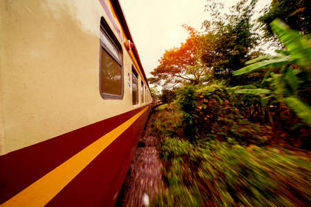 Passenger train cars view from window in Thailand. Railway between Bangkok and Chiang Mai. Motion blur.のeditorial素材