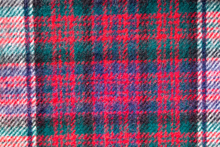 Close up of traditional Scottish woolen tartan fabric. Checkered cashmere plaid.