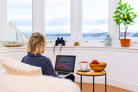 Businesswoman working from home with laptop. Online business career. Freelance writer editor or blogger on Quarantine at domestic workplace. Concept of a work remotely from home at cosy atmosphere.の写真素材