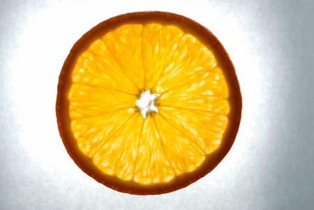 orange slice on grey background, illuminatedの写真素材