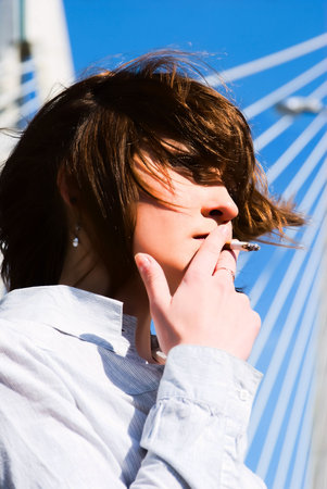 young smoking woman on a bridge