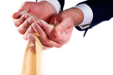 sand pouring out of businessman handsの写真素材