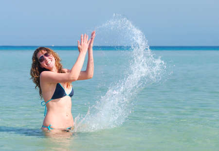 funny woman splashing in the seaの写真素材