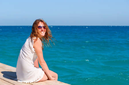 beautful woman sitting on the pierの写真素材