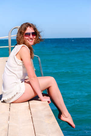 beautiful woman sitting alone on the pier の写真素材
