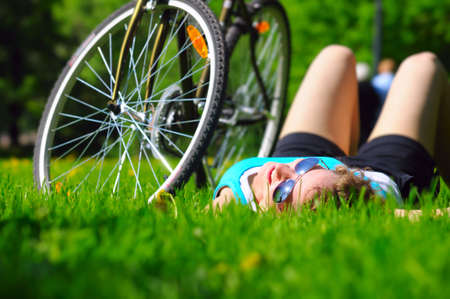 woman is lying near her bicycleの写真素材