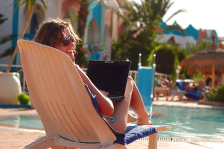 woman in tropical hotel with laptopの写真素材