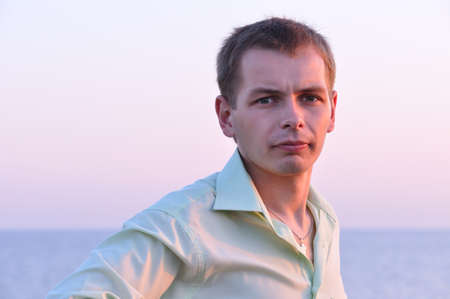 serious adult man at sunrise near the seaの写真素材