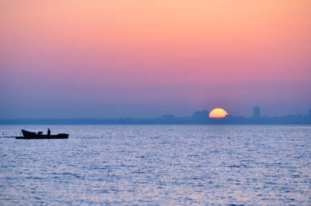 city silhouette from sea at sunriseの写真素材