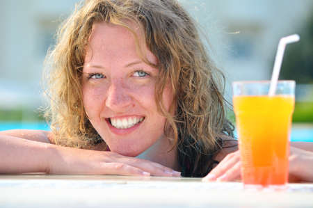 close up of pretty woman in swimming pool with cocktailの写真素材