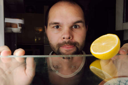 hungry young unshaved man is looking for foodの写真素材