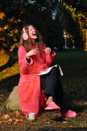 happy woman is laughing on magazine at forest in undressの写真素材