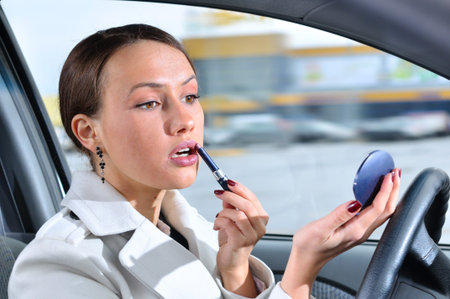 elegant woman is doing makeup on the run in her car 