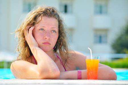sad pretty bored woman is boring in the hotel swimming pool の写真素材