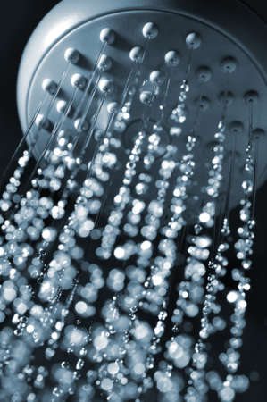 closeup view of water flowing out of shower in dark の写真素材