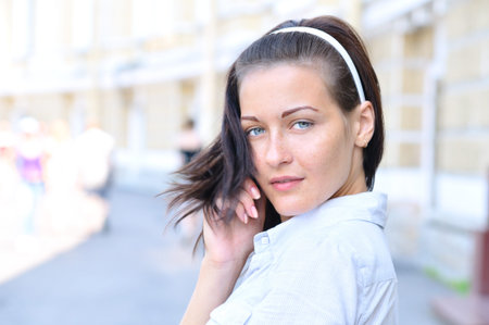 Sensual woman is looking back at sunny streetの写真素材