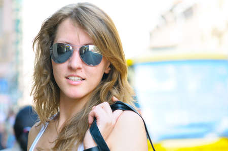 young smiling woman on bright city street の写真素材
