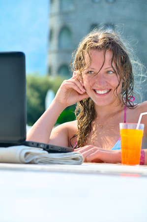 beautiful woman is using laptop in the swimming poolの写真素材