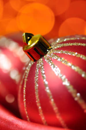 christmas decorative balls on red silk against blurred lights on backgroundの写真素材