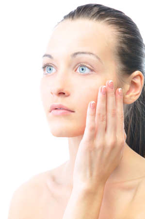 beautiful woman is touching her face, isolated on whiteの写真素材