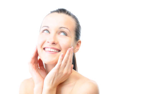 beautiful happy woman is looking sideways and touching her faceの写真素材