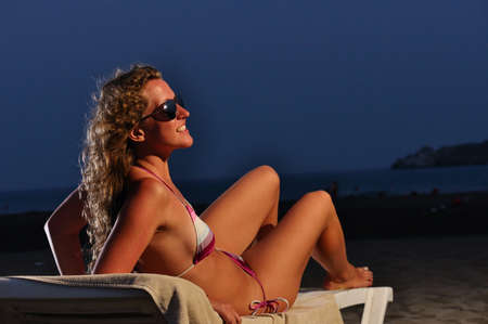 happy woman is lying on the night beachの写真素材