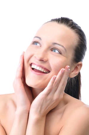 beautiful happy woman is looking sideways and touching her faceの写真素材