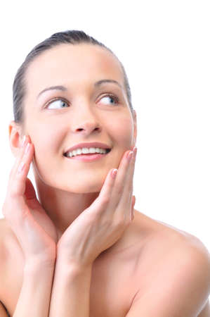 beautiful happy woman is looking sideways and touching her faceの写真素材