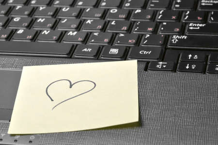 computer keyboard with heart on sticky noteの写真素材