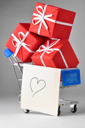 closeup of a shopping cart with gifts and heartの写真素材