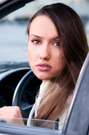 sensual young woman is looking at camera from a car の写真素材