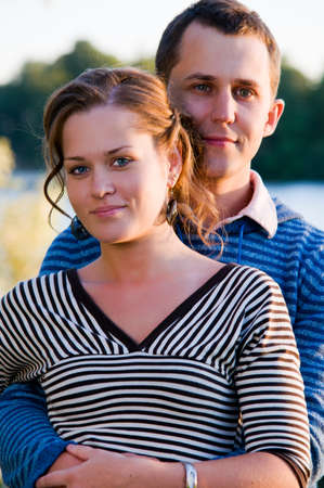 young attractive couple near lake at sunsetの写真素材