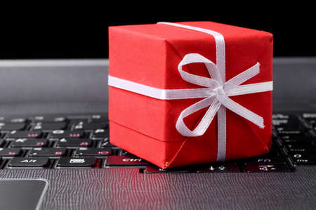 red gift box on a laptop keyboard の写真素材