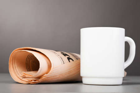 white cup and folded newspaperの写真素材