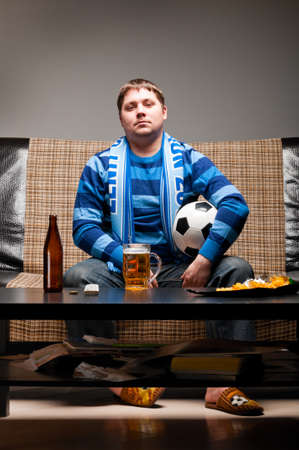 soccer fan on sofaの写真素材
