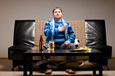 soccer fan on sofaの写真素材