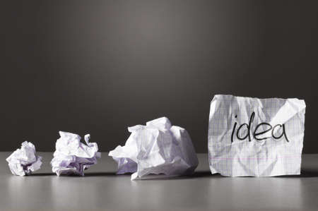 sheet of paper with word idea and crumpled wads on table.の写真素材