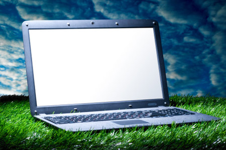 modern laptop with blank screen on grass outdoorsの写真素材
