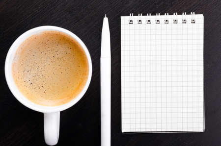 cup of coffee and notebook on table, top viewの写真素材