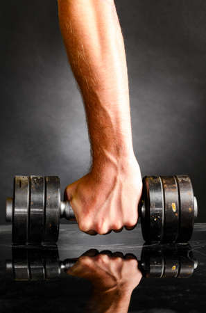 male hand is holding metal barbellの写真素材
