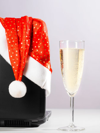 laptop with santa hat and sparkling wine on grayの写真素材