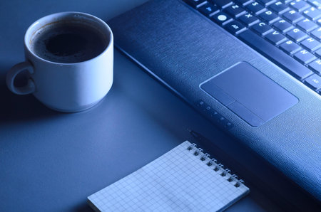 working at night, laptop and cup of hot coffee on table