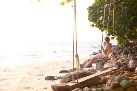 woman on swing at beachの写真素材