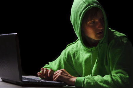 young hacker with laptop is turning his head around