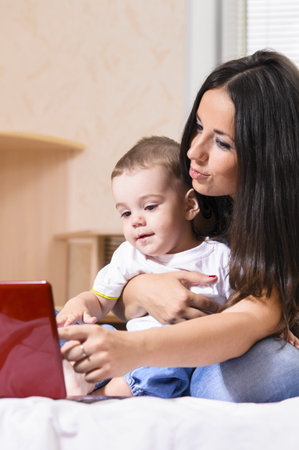 mother and son are using laptop at home
