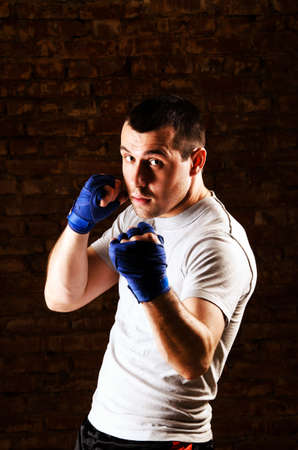 portrait of mma fighter in boxing pose against brick wallの写真素材
