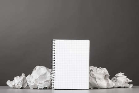 creative process  crumpled wads and notebook on grayの写真素材