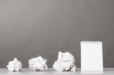 creative process  crumpled wads and notebook on grayの写真素材
