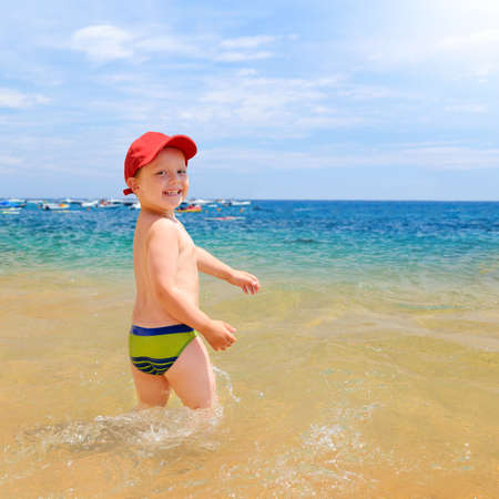 young boy is looking at camera in seasideの写真素材