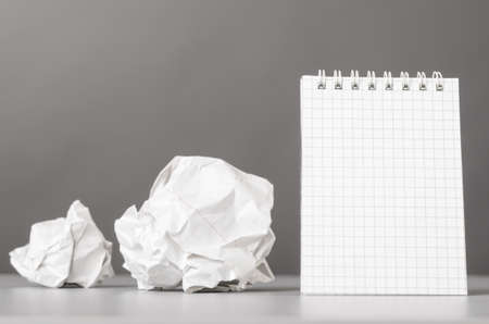 creative process  crumpled wads and notebook on grayの写真素材